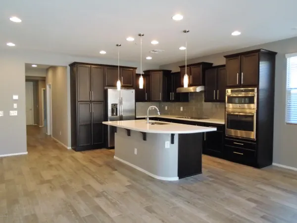 a kitchen with stainless steel appliances granite countertop a sink refrigerator and cabinets