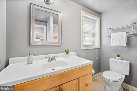 a bathroom with a sink toilet and a mirror