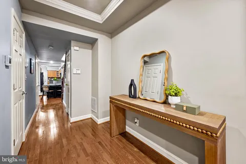 a view of a hallway to a livingroom with wooden floor