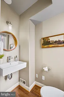 a bathroom with a sink a toilet and a mirror