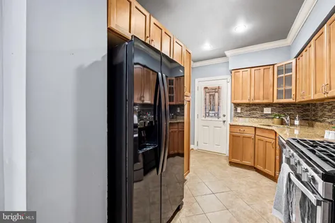 a kitchen with stainless steel appliances granite countertop a refrigerator and a stove top oven