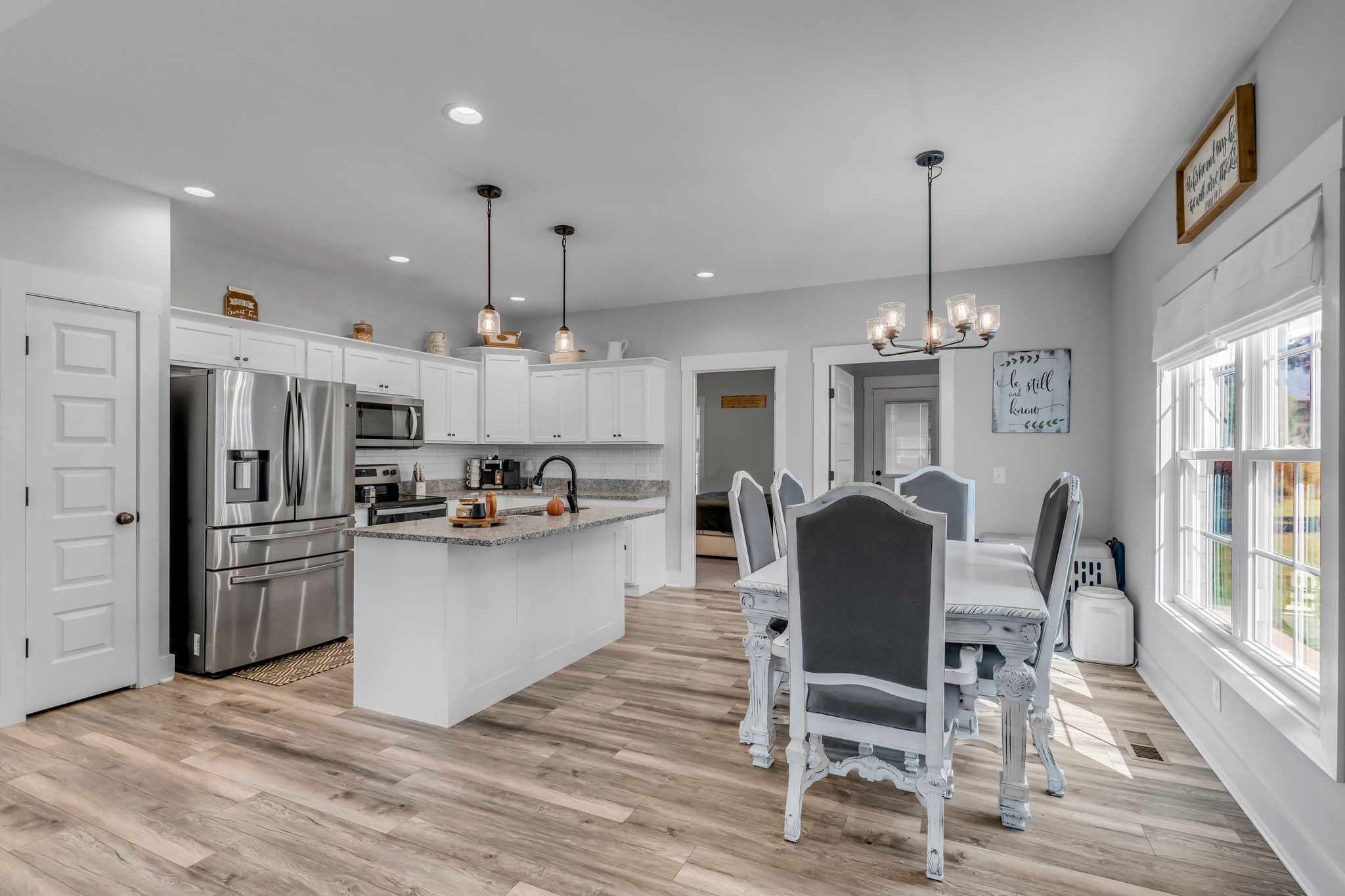 195 Julia Ann Court Springfield, TN 37172 - Photo 13 of 28 a kitchen with stainless steel appliances kitchen island granite countertop a dining table chairs and white cabinets