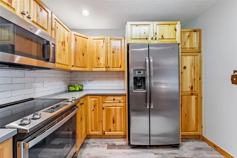a kitchen with stainless steel appliances granite countertop a refrigerator and a stove