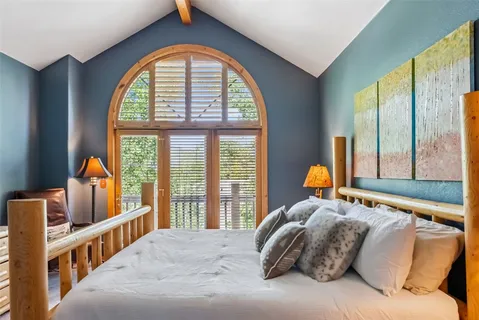 a bedroom with a bed and a large window