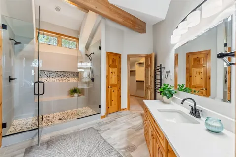 a bathroom with a granite countertop sink a mirror and shower