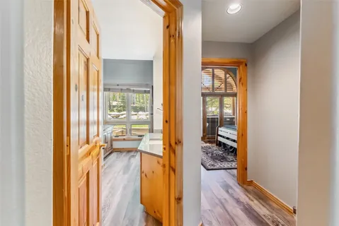 a view of a hallway with wooden floor and windows