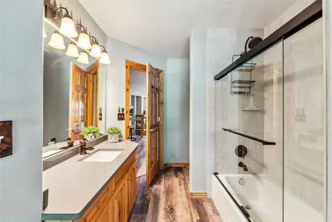 a bathroom with a double vanity sink a mirror and a bathtub