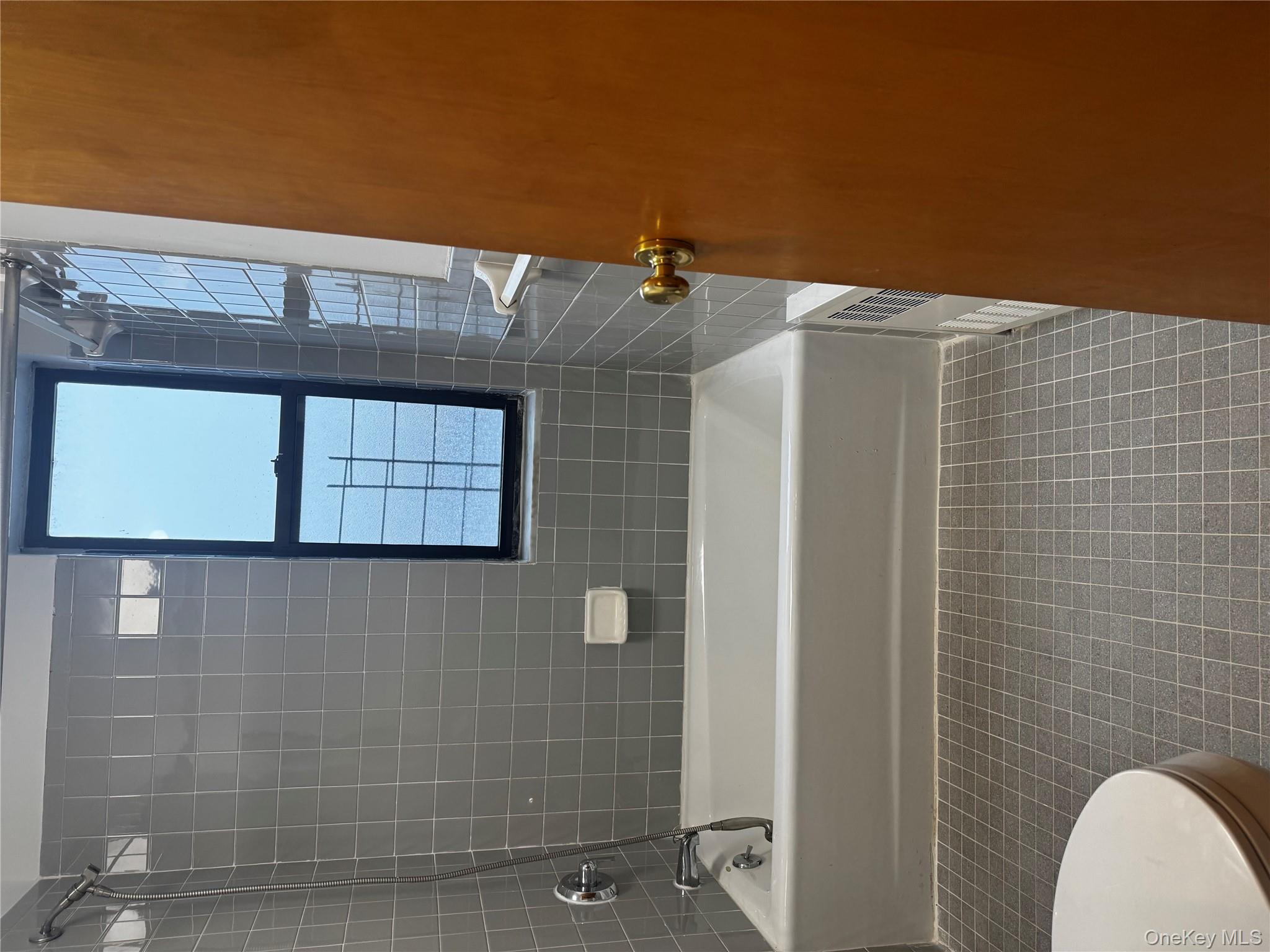 875 Longfellow Avenue, Unit 4C Bronx, NY 10474 - Photo 4 of 4 Bathroom with shower / bath combination and dark tile patterned flooring