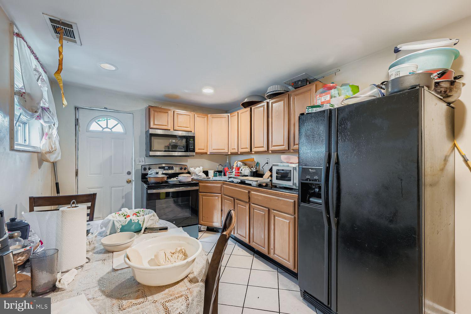 329 South Gilmor Street Baltimore, MD 21223 - Photo 8 of 28 a kitchen with stainless steel appliances a refrigerator a sink a stove a table and chairs