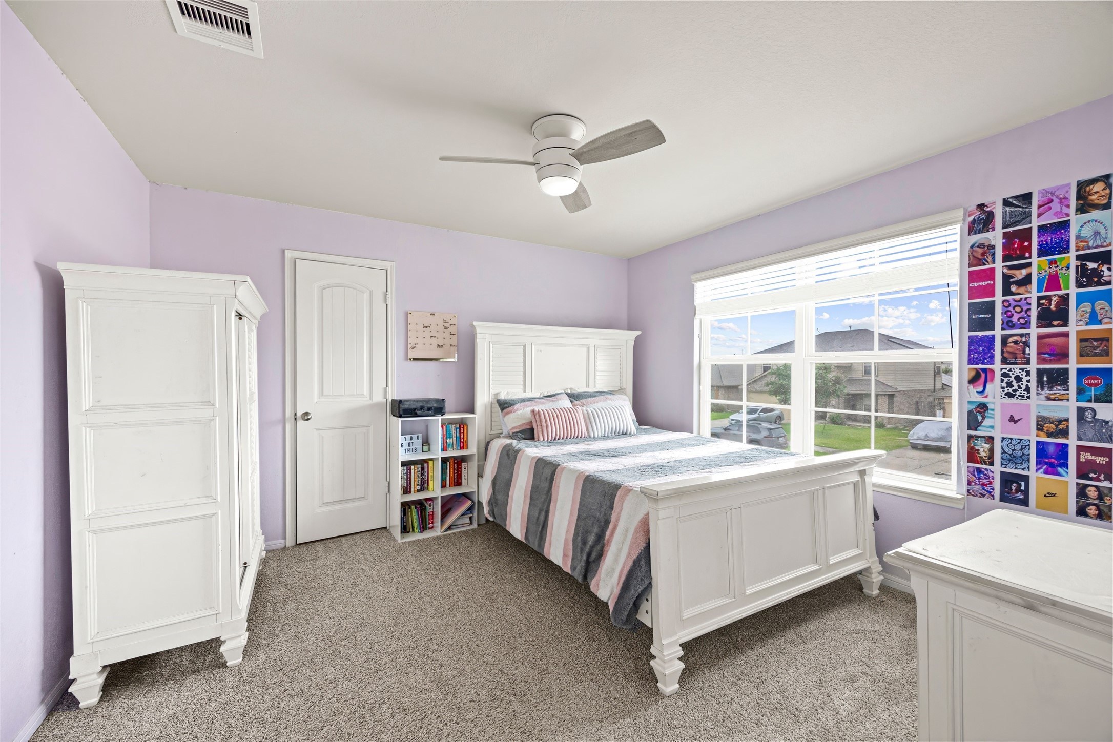 8026 Farthing Lane Rosharon, TX 77583 - Photo 9 of 13 Bright and cozy bedroom with light purple walls, featuring a white bedroom set, carpeted flooring, and a large window for natural light. Ideal for relaxation and comfort.