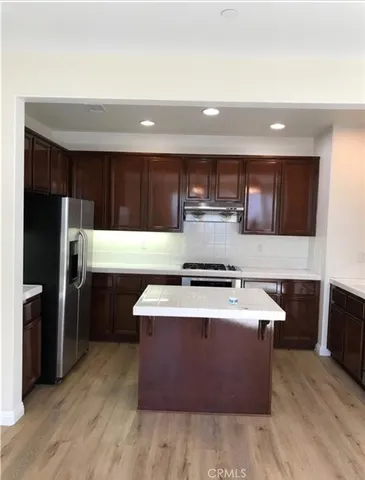 a kitchen with stainless steel appliances granite countertop a stove a refrigerator a sink and dishwasher