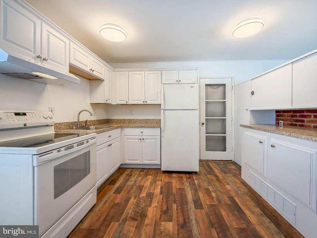 19 Butterfly Lane Levittown, PA 19054 - Photo 8 of 32 a kitchen with cabinets appliances and a wooden floor