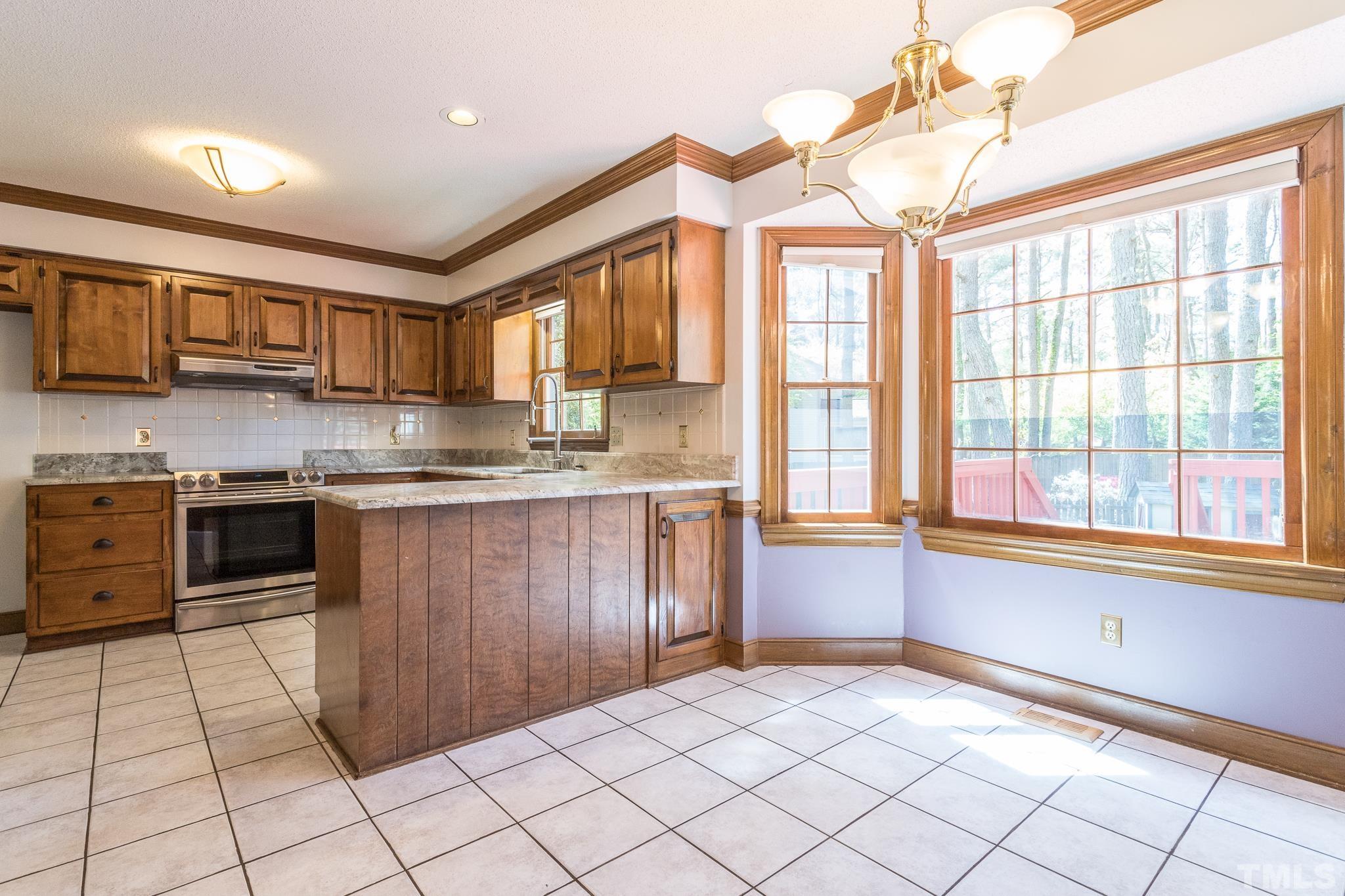 2700 Farnborough Road Raleigh, NC 27613 - Photo 14 of 36 a kitchen with stainless steel appliances granite countertop a stove a sink and a microwave
