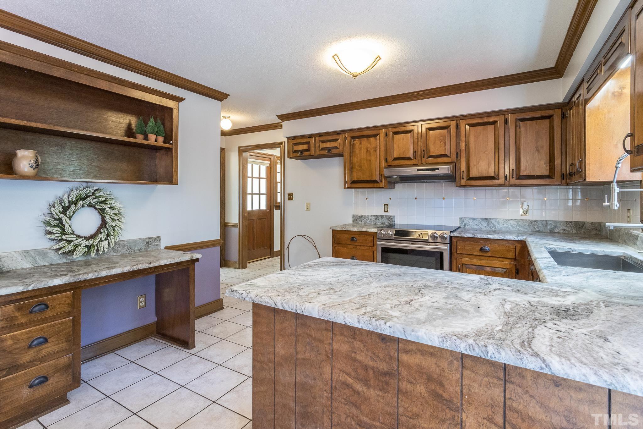 2700 Farnborough Road Raleigh, NC 27613 - Photo 17 of 36 a kitchen with stainless steel appliances granite countertop a sink a stove and a refrigerator