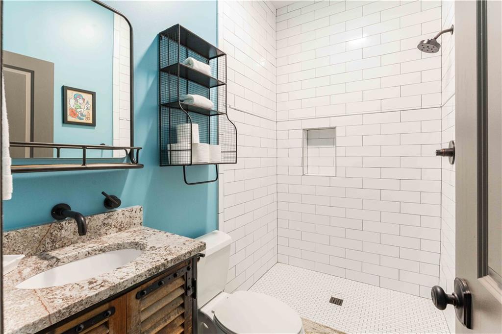 3118 West Roxboro Road Northeast Atlanta, GA 30324 - Photo 60 of 68 a bathroom with a granite countertop sink a toilet and shower