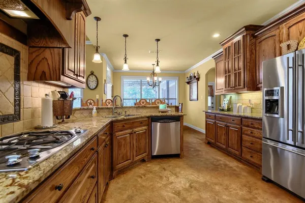 a kitchen with stainless steel appliances granite countertop a stove a sink and a refrigerator