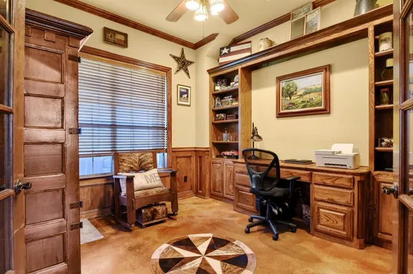 a view of a workspace with furniture and a window