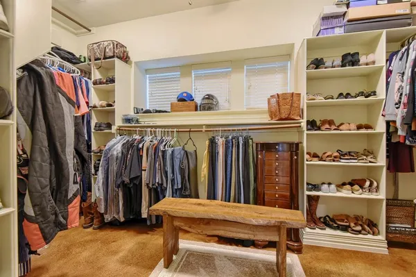 a view of walk in closet with clothes and shoes