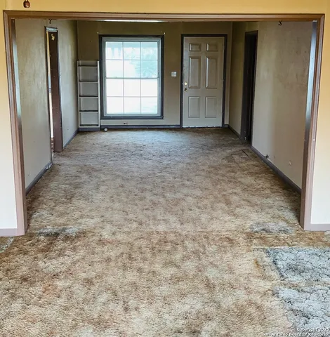 an empty room with closet and windows