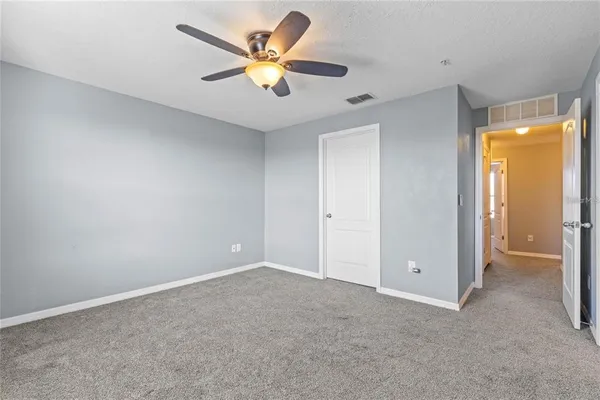 an empty room with a window and a ceiling fan