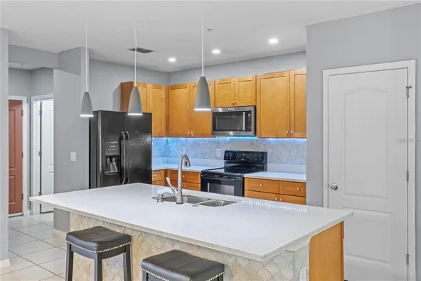a kitchen with stainless steel appliances granite countertop a sink a refrigerator and a stove