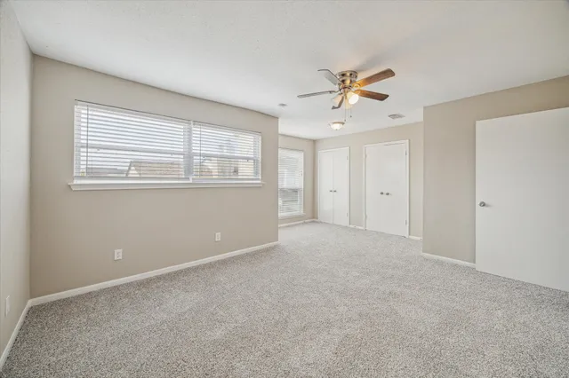 a spacious bedroom with a bed and a chandelier