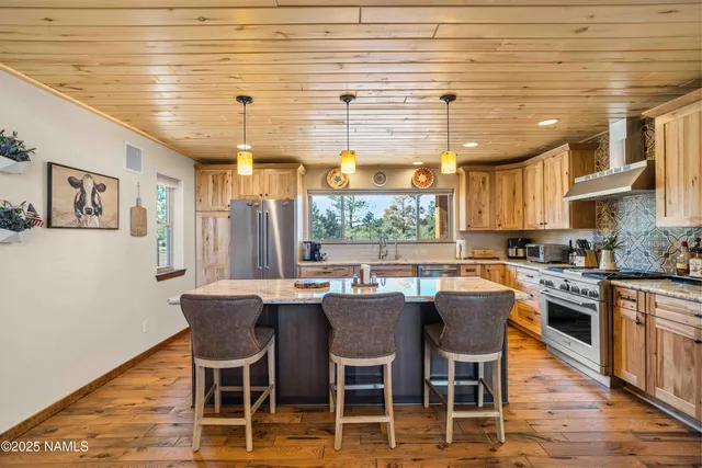 a dining room with stainless steel appliances kitchen island granite countertop a dining table chairs and a oven