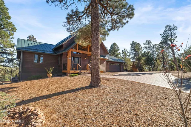 a view of backyard with wooden fence and large trees