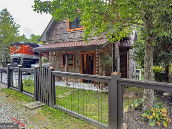 a view of a house with a wooden deck and a backyard