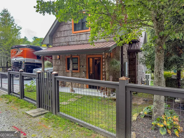 a view of a house with a wooden deck and a backyard