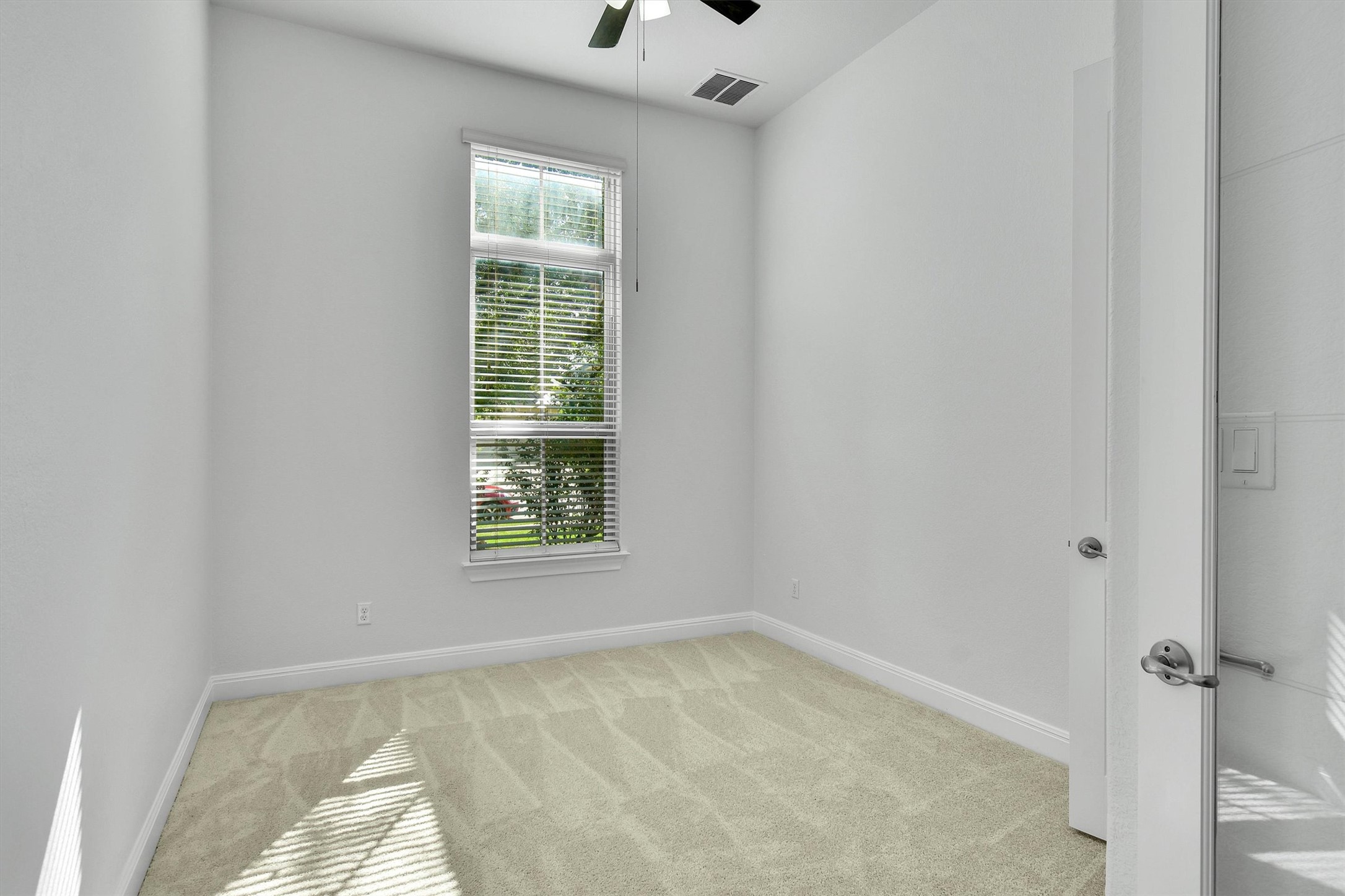 2325 Blended Tree Ranch Drive Leander, TX 78641 - Photo 20 of 35 A well-lit bedroom features plush carpeting and a large window, creating a serene and comfortable retreat.