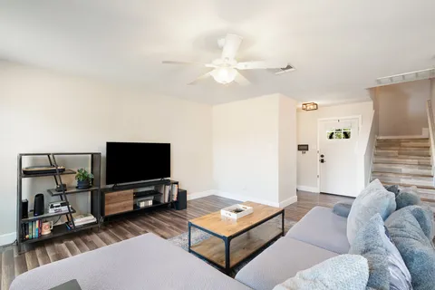 a living room with furniture a rug and kitchen view