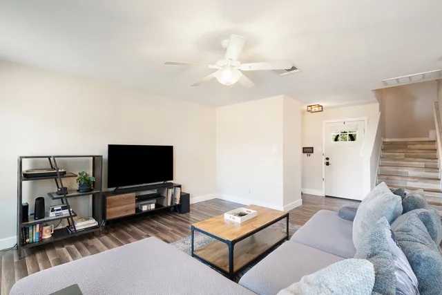 a living room with furniture a rug and kitchen view