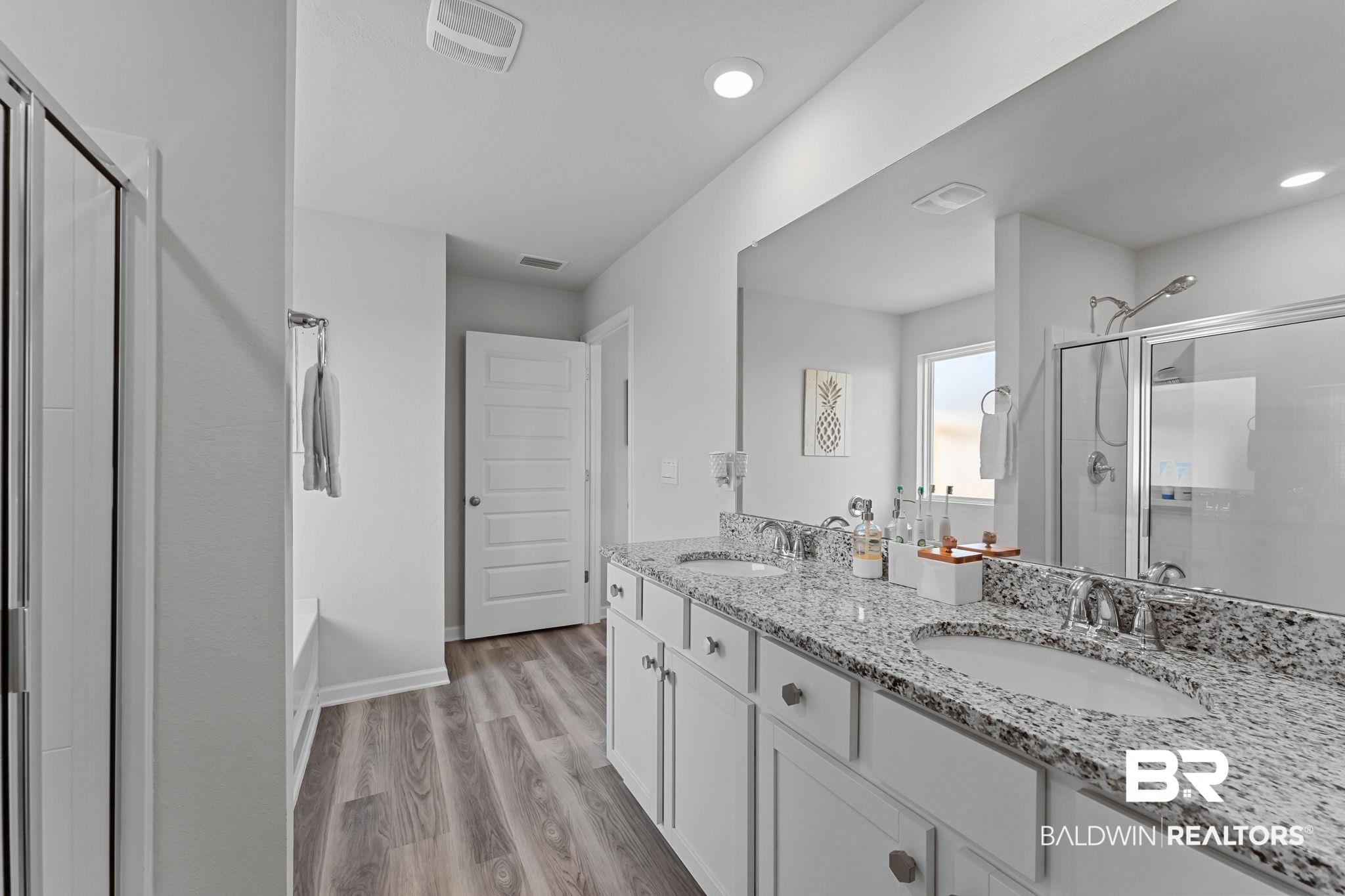 24337 Ringneck Loop Elberta, AL 36530 - Photo 16 of 34 Bathroom with a shower stall, double vanity, light wood-style flooring, a garden tub, and recessed lighting
