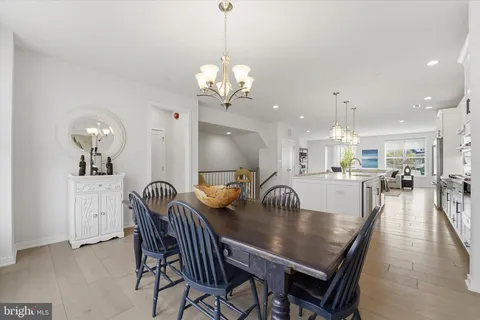 a view of a dining room and livingroom with furniture wooden floor a chandelier