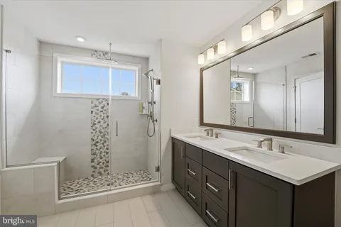 a bathroom with a shower sink and mirror