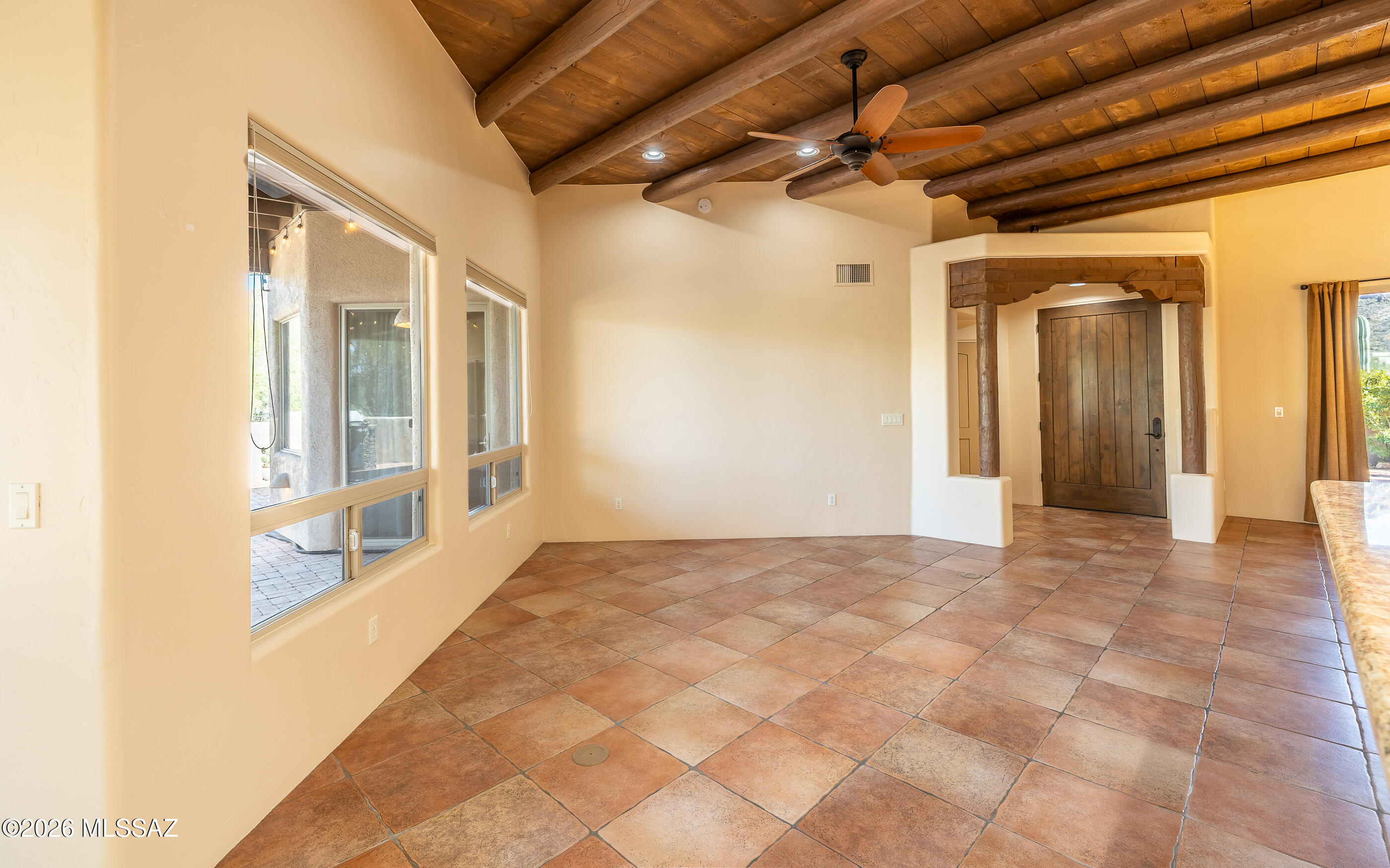 5550 West Open R Place Tucson, AZ 85713 - Photo 13 of 48 This inviting living area showcases authentic Southwestern architecture with exposed wooden vigas, complemented by a ceiling fan for added comfort!