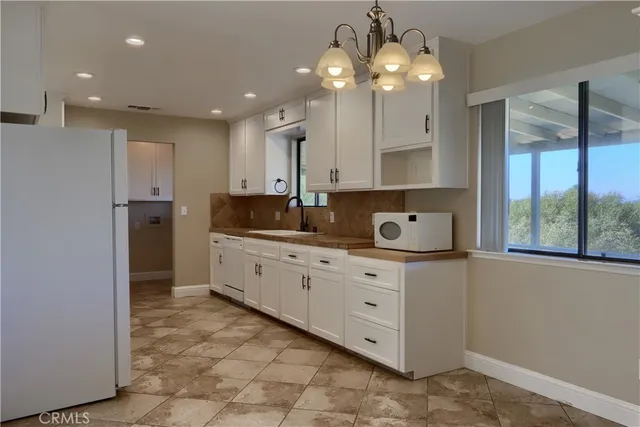 a kitchen with granite countertop white cabinets white appliances and granite counter tops