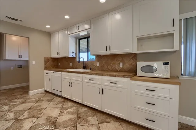 a kitchen with kitchen island a counter top space cabinets and stainless steel appliances