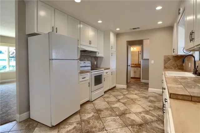 a kitchen with stainless steel appliances granite countertop a stove a sink and a refrigerator