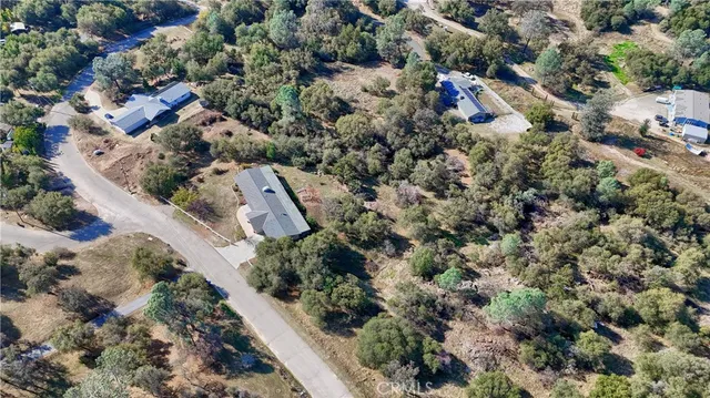 an aerial view of residential houses with outdoor space and trees