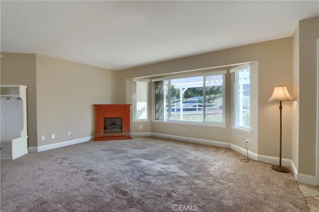 an empty room with windows and fireplace