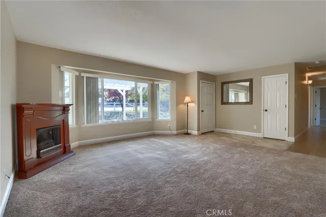 an empty room with windows and fireplace