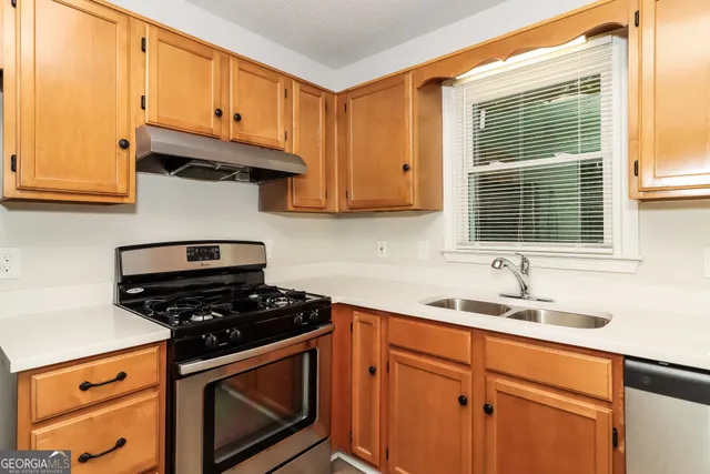 a kitchen with stainless steel appliances granite countertop a sink stove and cabinets