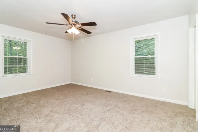 an empty room with a window and a fan