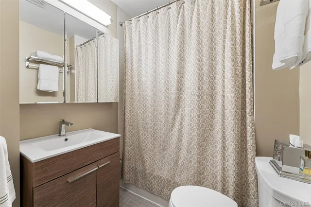 a bathroom with a sink a toilet and shower curtain