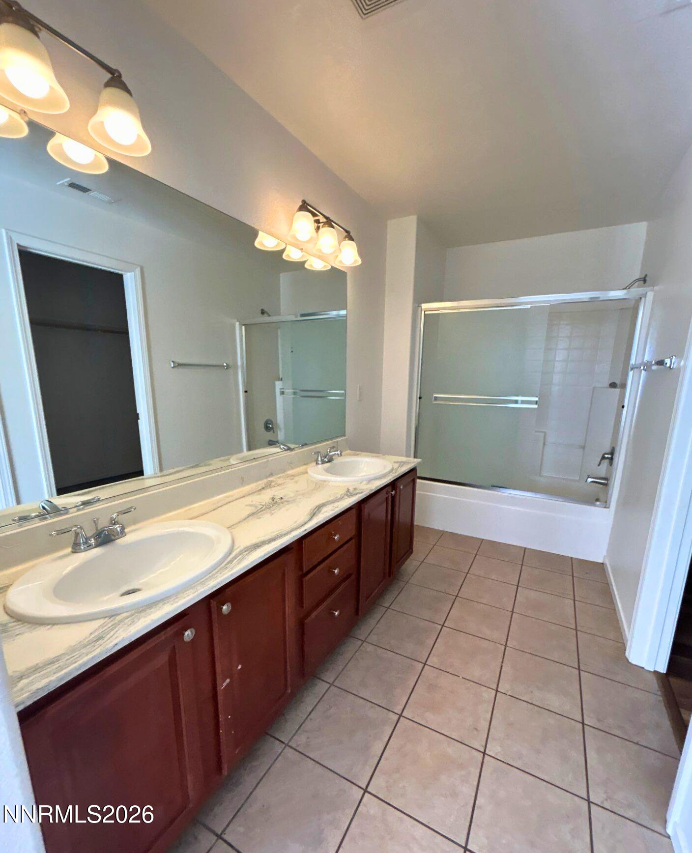7614 Corso Street Reno, NV 89506 - Photo 11 of 15 a bathroom with a sink a mirror and a shower