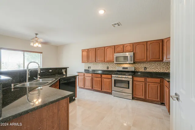 a kitchen with stainless steel appliances granite countertop a sink stove and refrigerator