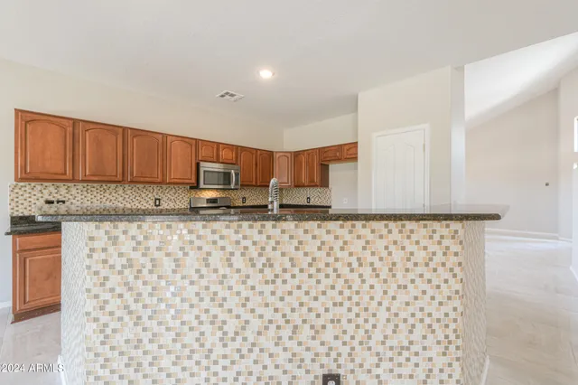 a view of a kitchen with wooden cabinets