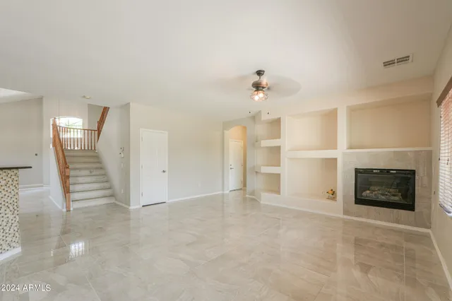 an empty room with fireplace and windows